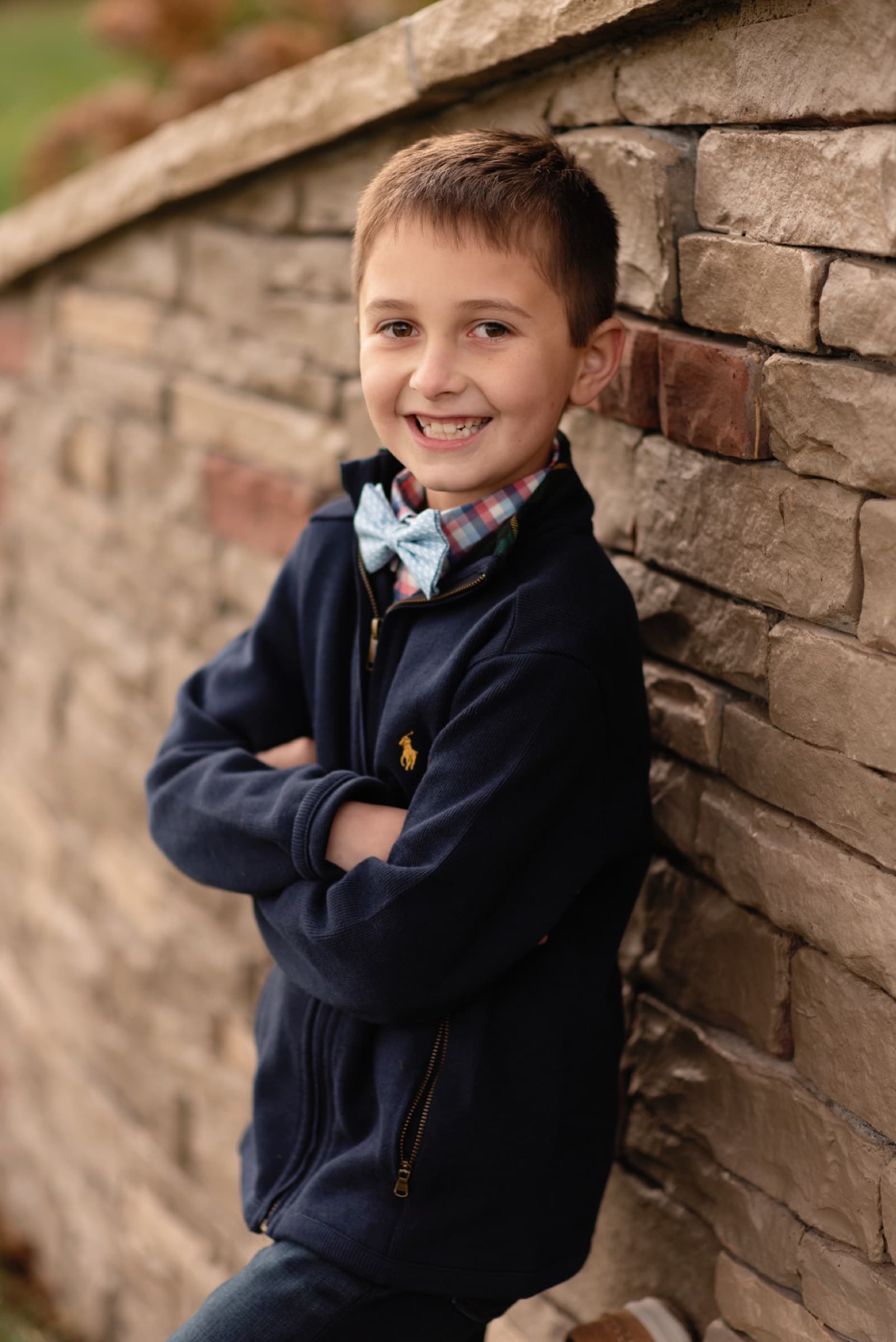 Natural child portrait beside a stone wall