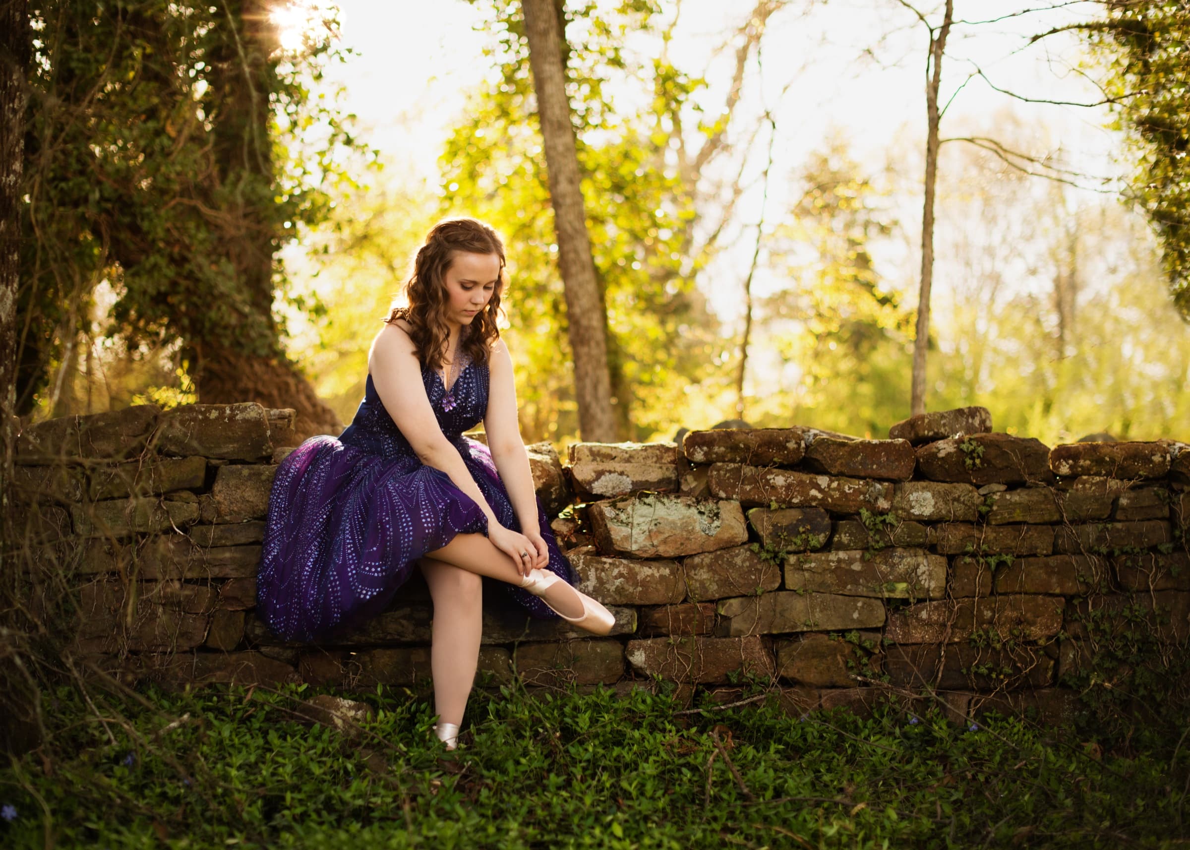 Senior portrait beside a historic stone wall