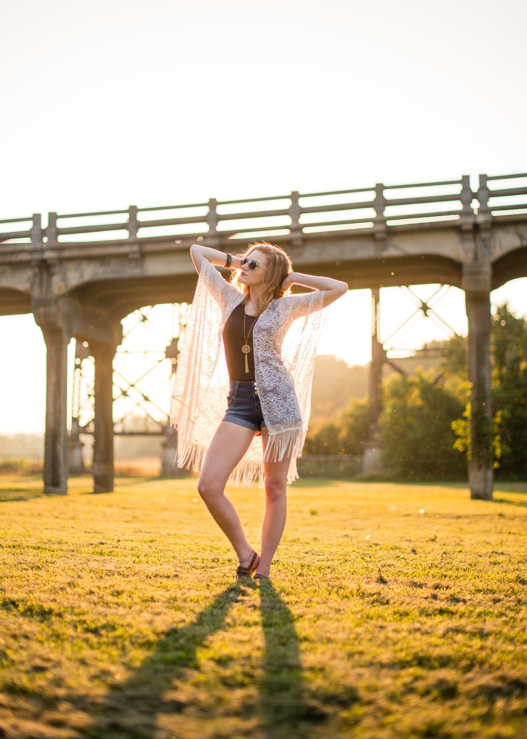Senior fashion portrait beneath an architectural bridge