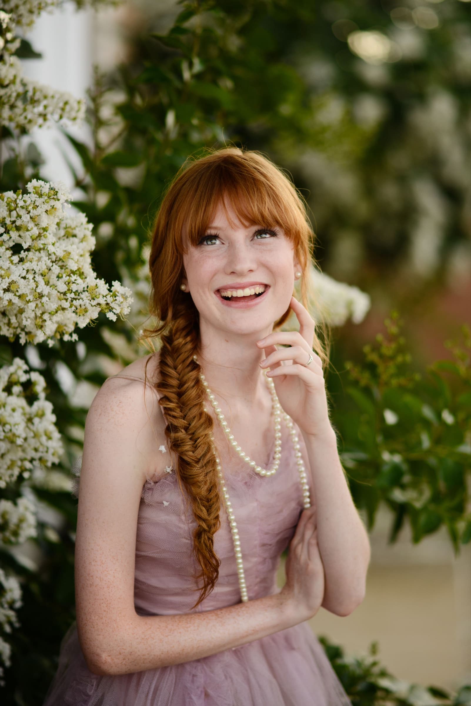 Joyful senior portrait among spring blossoms