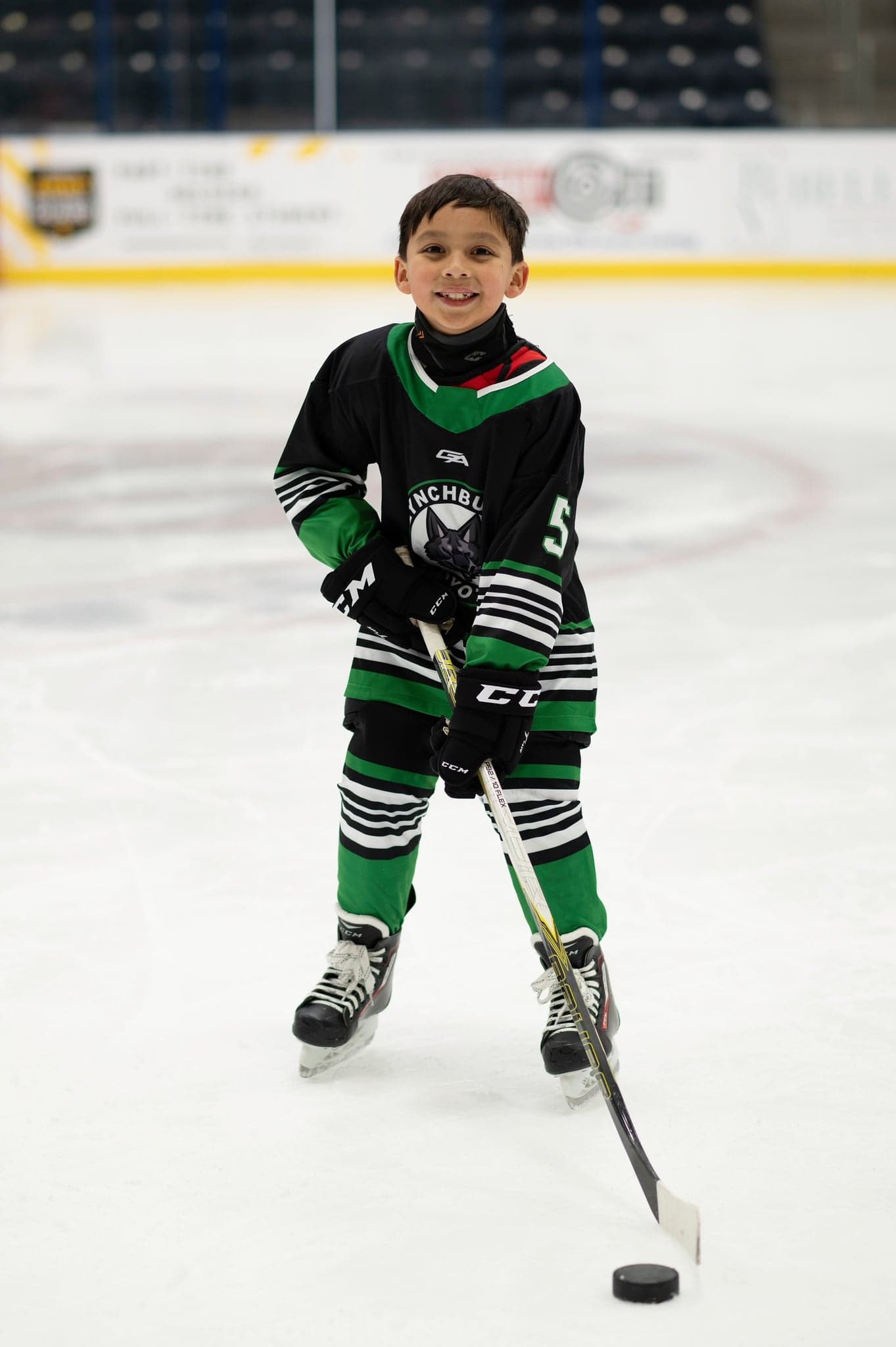 Coyotes player smiling with stick and puck at center ice