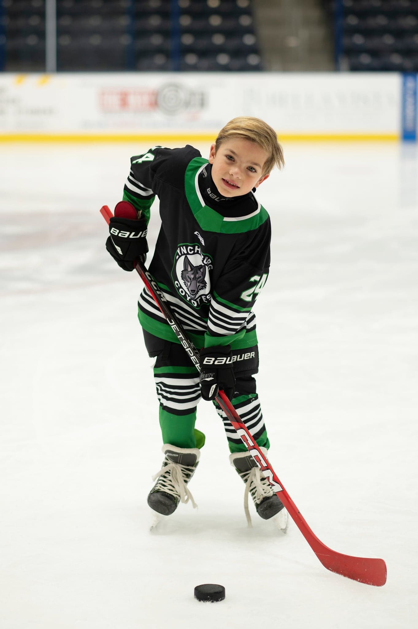 Coyotes player with a red stick, puck at the ready
