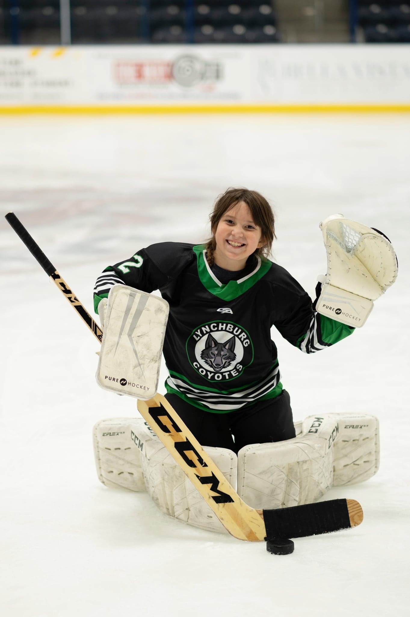 Coyotes goalie with glove raised, laughing in full pads