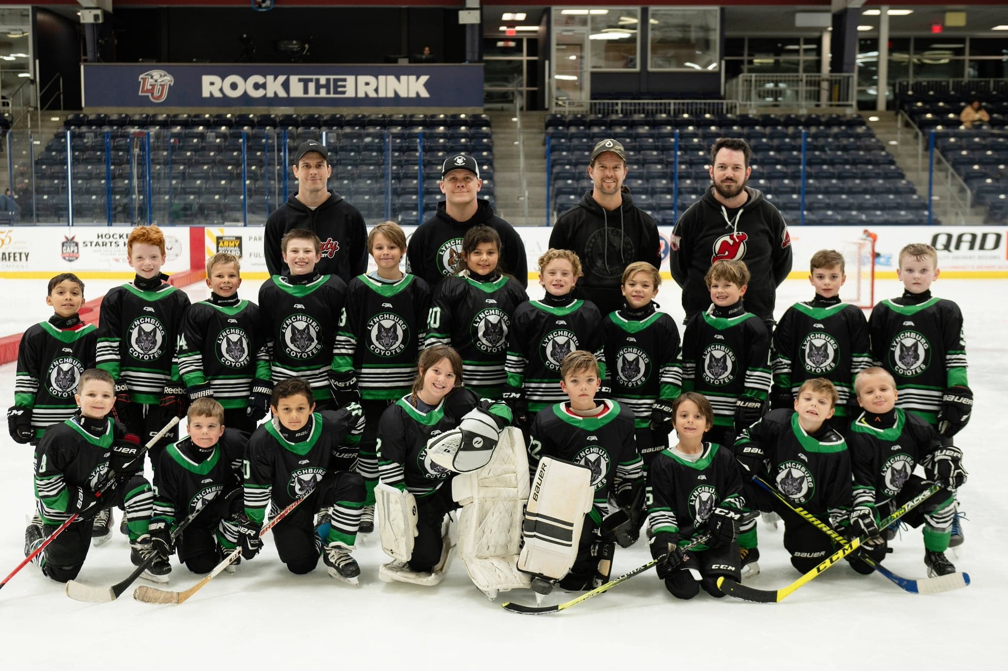 The Lynchburg Coyotes 8U team and coaches lined up at center ice for the team photo
